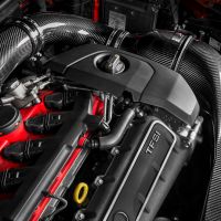 An automotive engine with a red and black color scheme features prominent carbon fiber air intake components, marked "TFSi," under an open hood displaying "EVENTURI" branding.