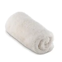 A rolled, fluffy, white towel sitting on a plain white background.