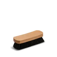 A rectangular wooden brush with black bristles lying horizontally on a white background.