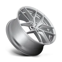A silver alloy wheel is angled vertically with prominent multi-spoke design. The hubcap center features the text, “oldandm." The surrounding environment is a plain, light background.