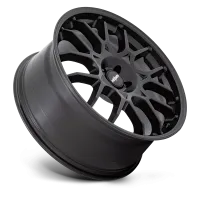 A matte black car wheel rim with a multi-spoke design lies at an angle against a plain black background; the center cap displays the text "rotiform."
