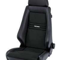 A black Recaro car seat features a cushioned headrest and firm padding. It is positioned upright against a plain white background. The Recaro logo is visible on the backrest.