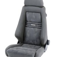A gray car seat with a headrest and an adjustable knob on the side is set against a plain white backdrop. The seat has "RECARO" written on the backrest.