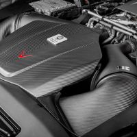 Engine showcasing a carbon fiber air filter cover and intake system, situated within the engine bay of a high-performance vehicle.