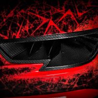 A carbon-fiber car exhaust vent on a red vehicle, surrounded by abstract, jagged red and black patterns, creating a dynamic and aggressive visual effect.