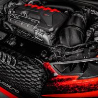 Audi Quattro engine with carbon fiber components is showcased under the hood, highlighted against a black background with red accents. The text visible includes "quattro," "TFSI," and the Audi logo.