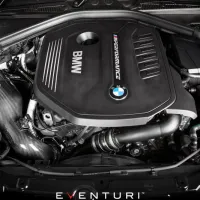 An engine labeled "BMW" and "M PERFORMANCE" is installed in a vehicle, with components including hoses and a carbon fiber air intake visible in a well-maintained engine bay. "EVENTURI" at the image bottom.