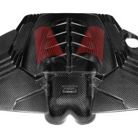 Carbon fiber engine cover featuring red air filters, labeled "EVENTURI MCLAREN 720S" on a small metallic plaque; part of a high-performance car's engine bay.