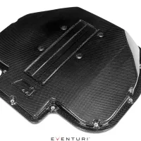 Carbon fiber engine cover with vent slots lying horizontally, surrounded by a white background. Below it, the text "EVENTURI."