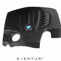 A carbon fiber BMW engine cover features the text "EVENTURI" vertically and the BMW logo centrally displayed. The background is plain white, highlighting the part's sleek design.