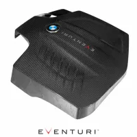 A carbon-fiber engine cover with a BMW logo and "EVENTURI" text, resting on a white background. The brand name "EVENTURI" appears prominently below the object.