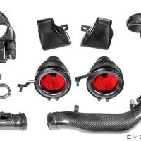 Carbon fiber car intake kit components, featuring red air filters, tubing, and mounting brackets, arranged neatly on a white background. Text reads: "EVENTURI".