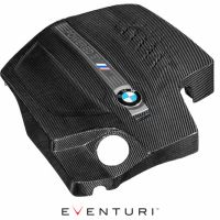 Carbon fiber engine cover for a BMW, featuring a label with "POWERED BY M" and the BMW logo. It is displayed on a white background with "EVENTURI" text below.