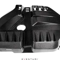 Rectangular, glossy carbon fiber vehicle engine cover with various geometric patterns and vents, and a central circular hole, placed against a white background. Text present: "EVENTURI".