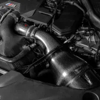 A sleek carbon fiber air intake with a "Venturi" logo is installed in a high-performance engine bay, surrounded by various cables, hoses, and engine components.