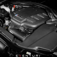 An engine with a black plastic cover and "M5" logo is installed in a car's engine bay. It is branded "EVENTURI" at the bottom of the image.