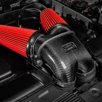 A dual air intake system with red air filters and a carbon fiber housing labeled "Eventuri" is installed in a car engine bay, surrounded by other engine components.