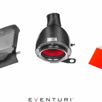 Eventuri carbon fiber air intake components laid out on a white background: a vented box (left), a cylindrical air filter with red interior (center), a flat red panel (right). Text: "EVENTURI".