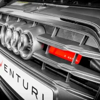 Car grille with four circular vents featuring the Audi logo and a red 'EVENTURI' branded filter, set within a modern garage environment. The license plate reads "EVENTURI".