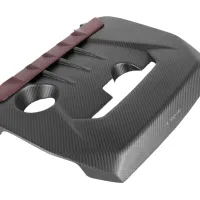 A black carbon fiber engine cover with two large circular openings and a red accent at the top. The word "EVENTURI" is visible near the bottom right corner.