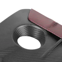 A carbon fiber panel with a circular cutout and red accent edge detailing, displayed against a white background.