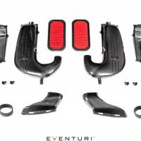 Carbon fiber automotive air intake kit, including curved ducts, cylindrical filters, couplers, and small components, laid out systematically on a white background. Text present: "EVENTURI."