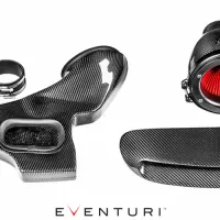 Carbon fiber car air intake system components, including a main intake assembly, cylindrical filter housing, and various connecting pieces, arranged on a white surface. Text: EVENTURI.