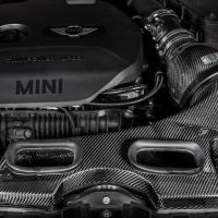 Engine compartment of a MINI car features a prominently displayed TwinPower Turbo engine cover and EVENTURI carbon fiber air intake system. The surroundings include various engine components and the Eventuri brand logo.