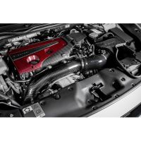 Engine components featuring a red and black carbon fiber cover with "Venturi" text, located inside a car's engine compartment, with various mechanical parts and wiring visible around.