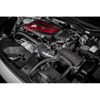 Engine bay with red-colored engine cover and carbon fiber components, featuring a Mishimoto air intake system, situated in a vehicle with various pipes and electronics around.