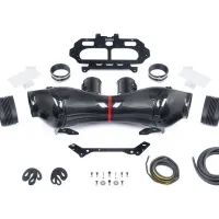 Carbon fiber intake pipes, laid out with various connecting parts, rubber hoses, clamps, bolts, and brackets, arranged neatly on a white surface, likely for a vehicle's intake system assembly.