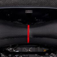 Carbon fiber air intake with a red strap labeled "EVENTURI," positioned under a black hood with a small "Eventuri" plaque. Surrounding area shows part of the car's engine bay.