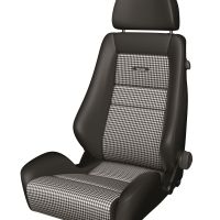 A black car seat with houndstooth fabric inserts and an integrated headrest is set against a plain white background. The seat features the word "RECARO" embroidered on the backrest.
