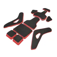 Black and red foam padding pieces are arranged on a white surface, likely designed for insertion into a helmet or other protective gear.