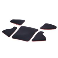Five black cushioned pads with red edges lie on a white surface, each varying in shape, possibly for ergonomic support or padding purposes.