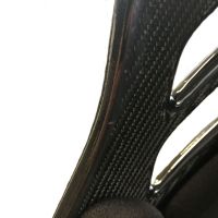 Carbon fiber panel with a curved edge and foam padding, situated in a white, minimalistic environment.