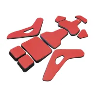 Red and black foam pads with various shapes and sizes laid out on a white background, likely components for protective gear or cushioning.
