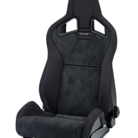 Black racing car seat with ergonomic design and branding text "RECARO" on the headrest area, placed against a plain, black background.