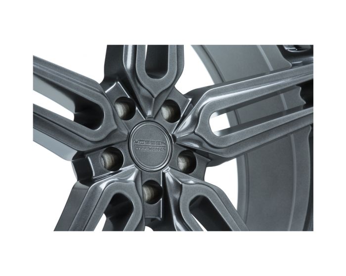 A metallic car wheel rim features five spokes extending from a central hub. The text on the hub reads "Vossen Hybrid Forged." The background is plain white.