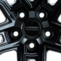 A shiny black alloy wheel with five bold spokes and a circular center, featuring the text "VOSSEN HYBRID FORGED," surrounded by bolt holes against a white background.