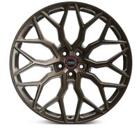 A bronze, intricately designed car wheel displays multiple angular spokes. In the center, the text "VOSSEN FORGED" is visible, emphasizing brand identity. The wheel rests against a plain white background.