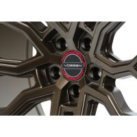 A metallic wheel rim with a bronze finish displays a red and black center cap labeled "VOSSEN," set against a plain white background.