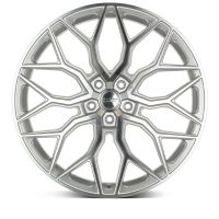 A silver car rim features an intricate, geometric spoke design. In the center, text reads "HEXEN WHEELS AND DESIGNS," surrounded by a simple white background.