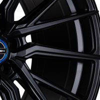 A sleek black alloy car wheel rim with intricate spokes, featuring a blue and black center cap labeled "VOSSEN," set against a plain white background.