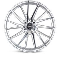 A silver alloy wheel with a multi-spoke design rests on a white background. The center cap features the text: "VOSSEN FORGED ENGINEERED ARTISAN SERIES."