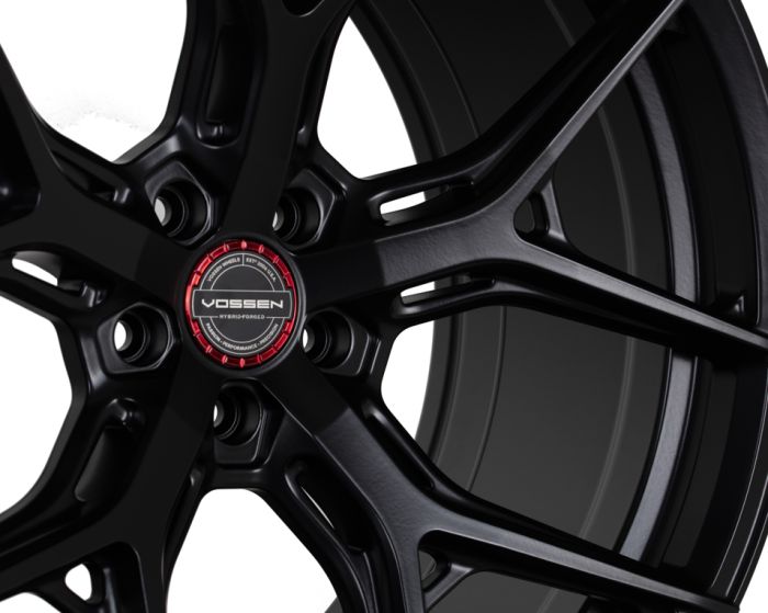 Black alloy wheel with a five-spoke design, displaying "VOSSEN HYBRID FORGED" in the center, set against a plain white background.