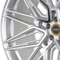A detailed silver alloy wheel with an intricate pattern featuring a central hubcap labeled "VOSSEN," set against a neutral background.