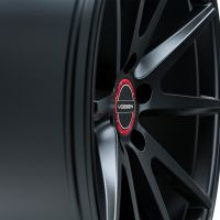 A sleek, black alloy wheel with a multi-spoke design displays the "VOSSEN" logo on a red circular center cap, photographed against a white background.