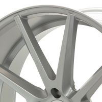 A close-up of a metallic car wheel rim with a modern, multi-spoke design in a studio setting, emphasizing its smooth, polished finish.