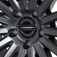 A metallic car wheel with intricate spokes, featuring a central hubcap labeled "Vossen Hybrid Forged." Surrounding text reads: "Vossen Wheels Est. 2006 U.S.A., Passion - Performance - Precision."